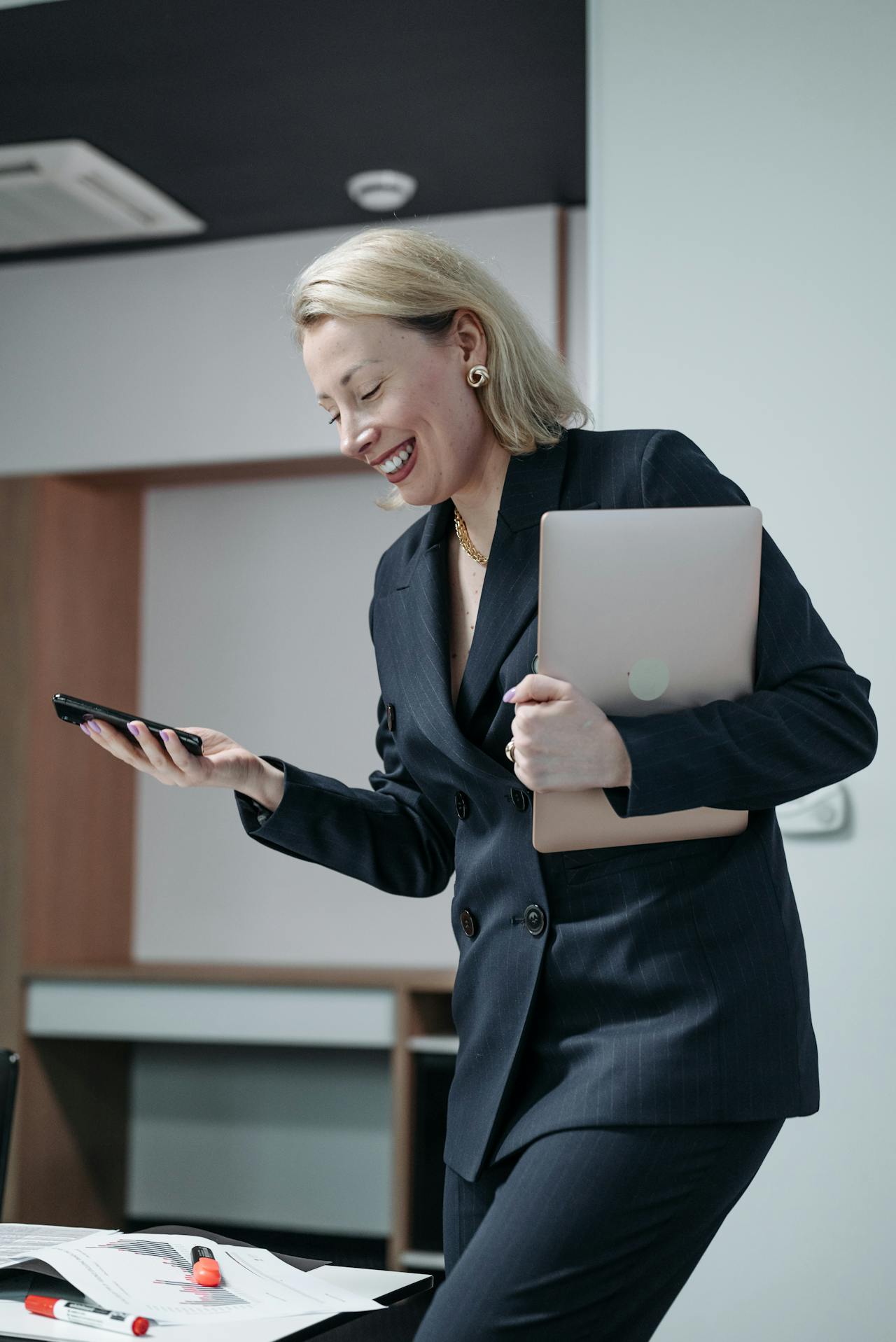 business woman smiling whilst looking at her phone