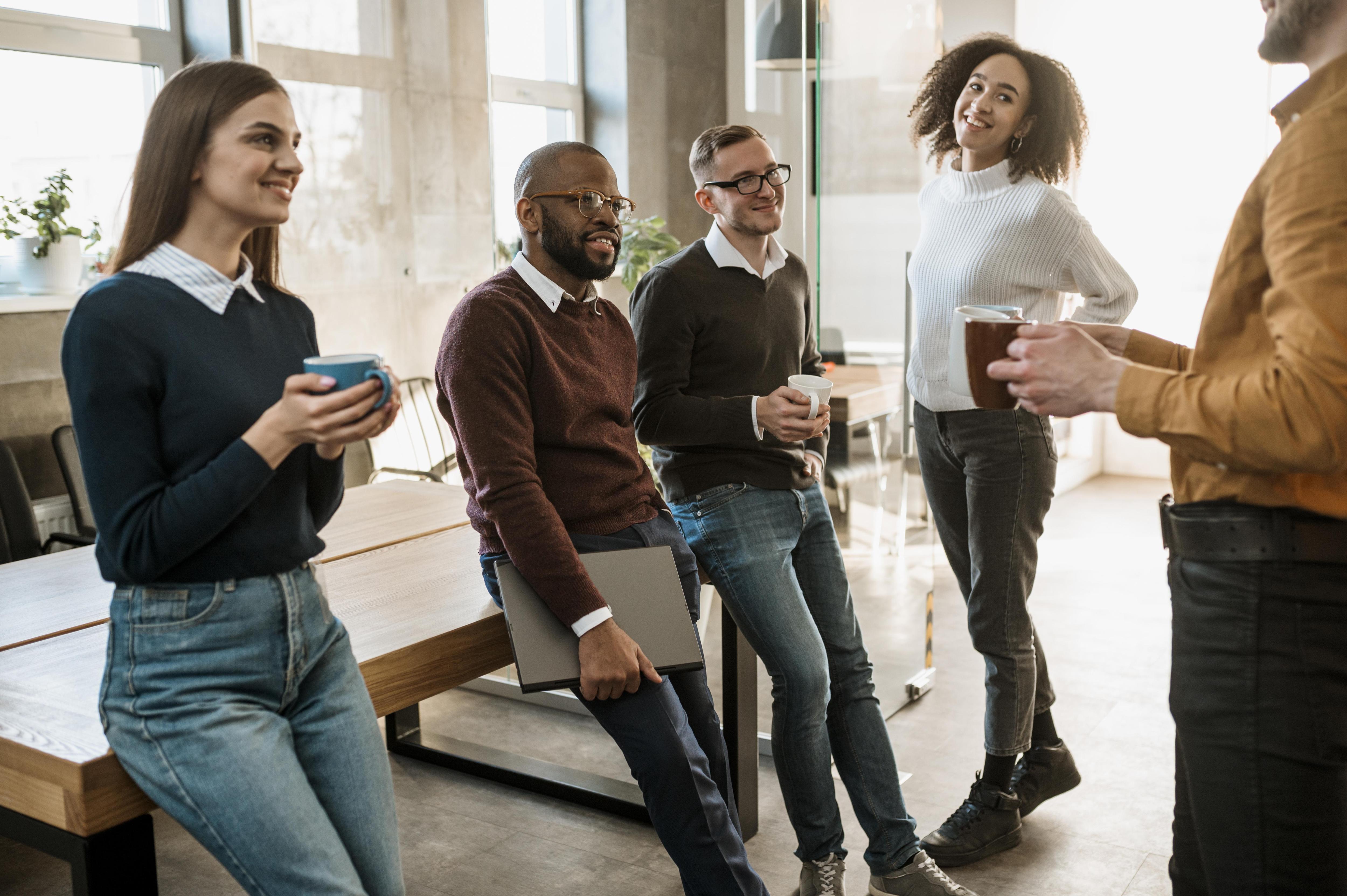 A diverse group of professionals engaged in a discussion within a modern office setting.