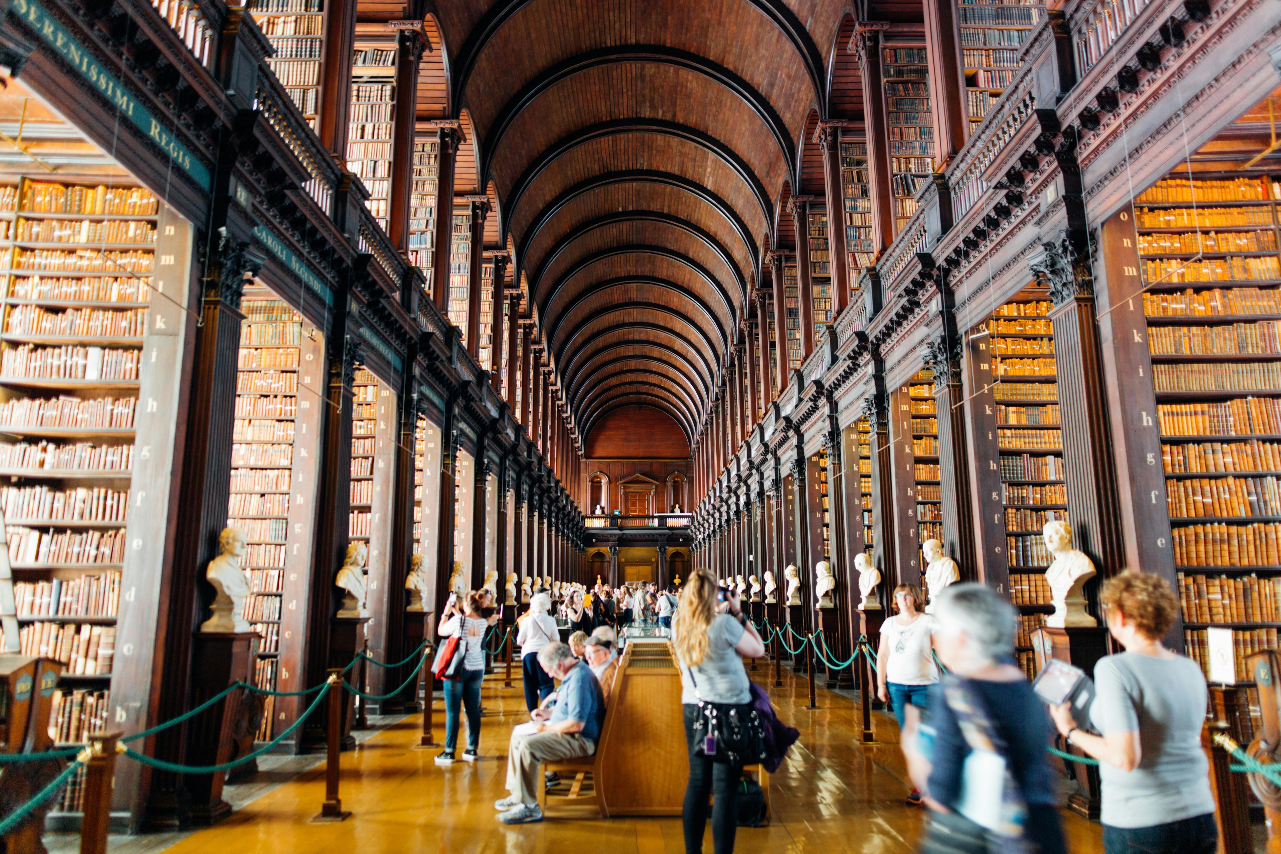 An image of a long hall with ceiling height book shelves on either side extending into the distance